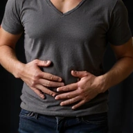 Gyomorpanaszokat jelző ember, kezét a hasán tartva